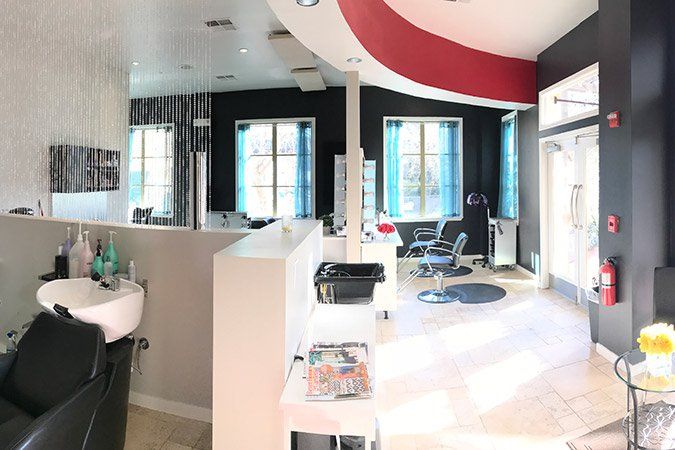 A salon with a sink and chairs and a fire extinguisher.