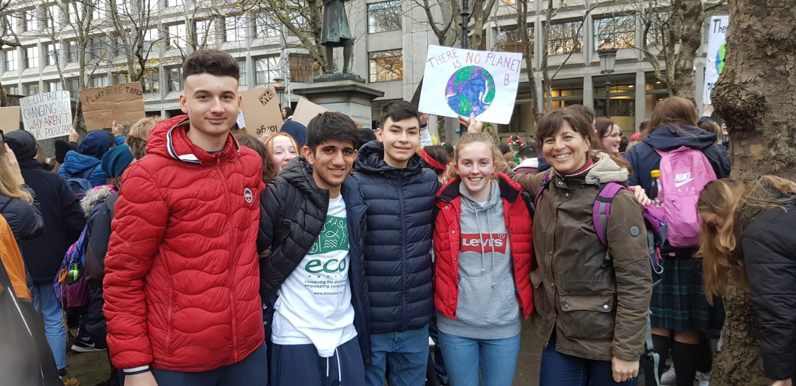 a group of people holding a sign that says there is no planet b