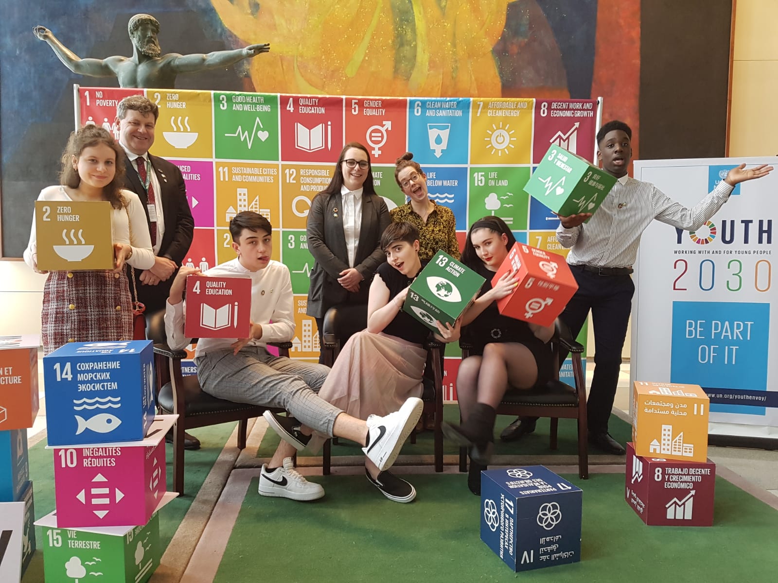 a group of people standing in front of a sign that says youth 2030