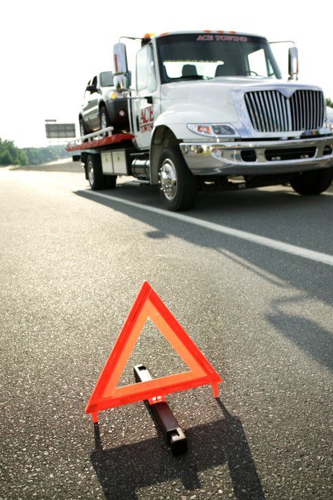 Safety triangle and tow truck on highway - Towing Services and Auto Repair in Hinckley, MN Safety triangle and tow truck on highway - Towing Services and Auto Repair in Hinckley, MN