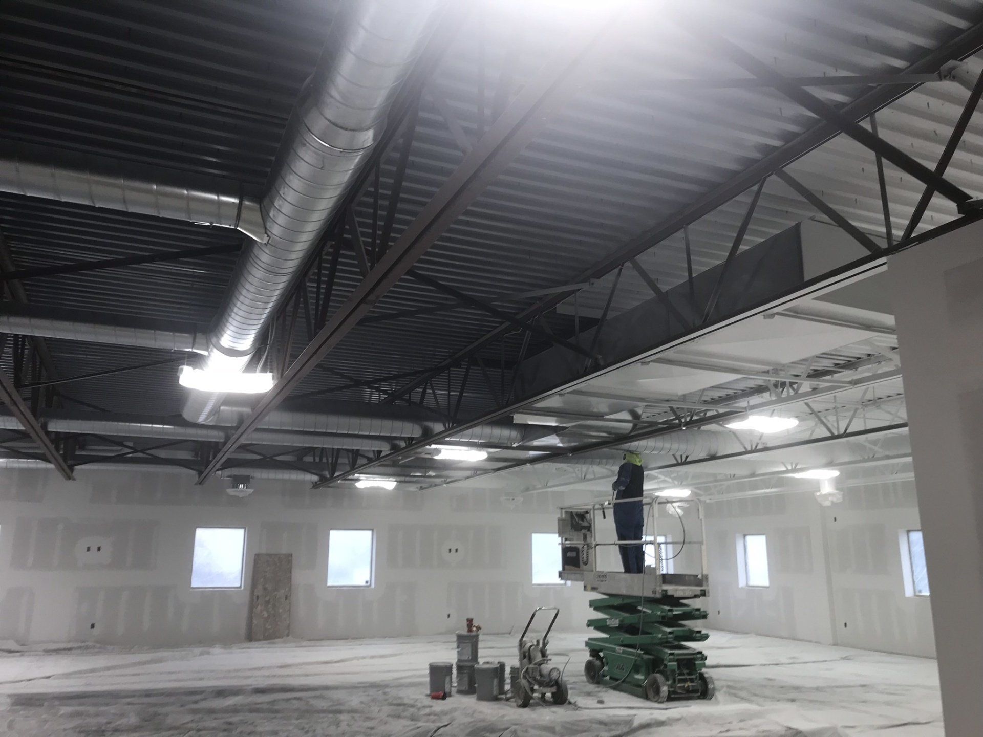 a man is standing on a lift in a large room .