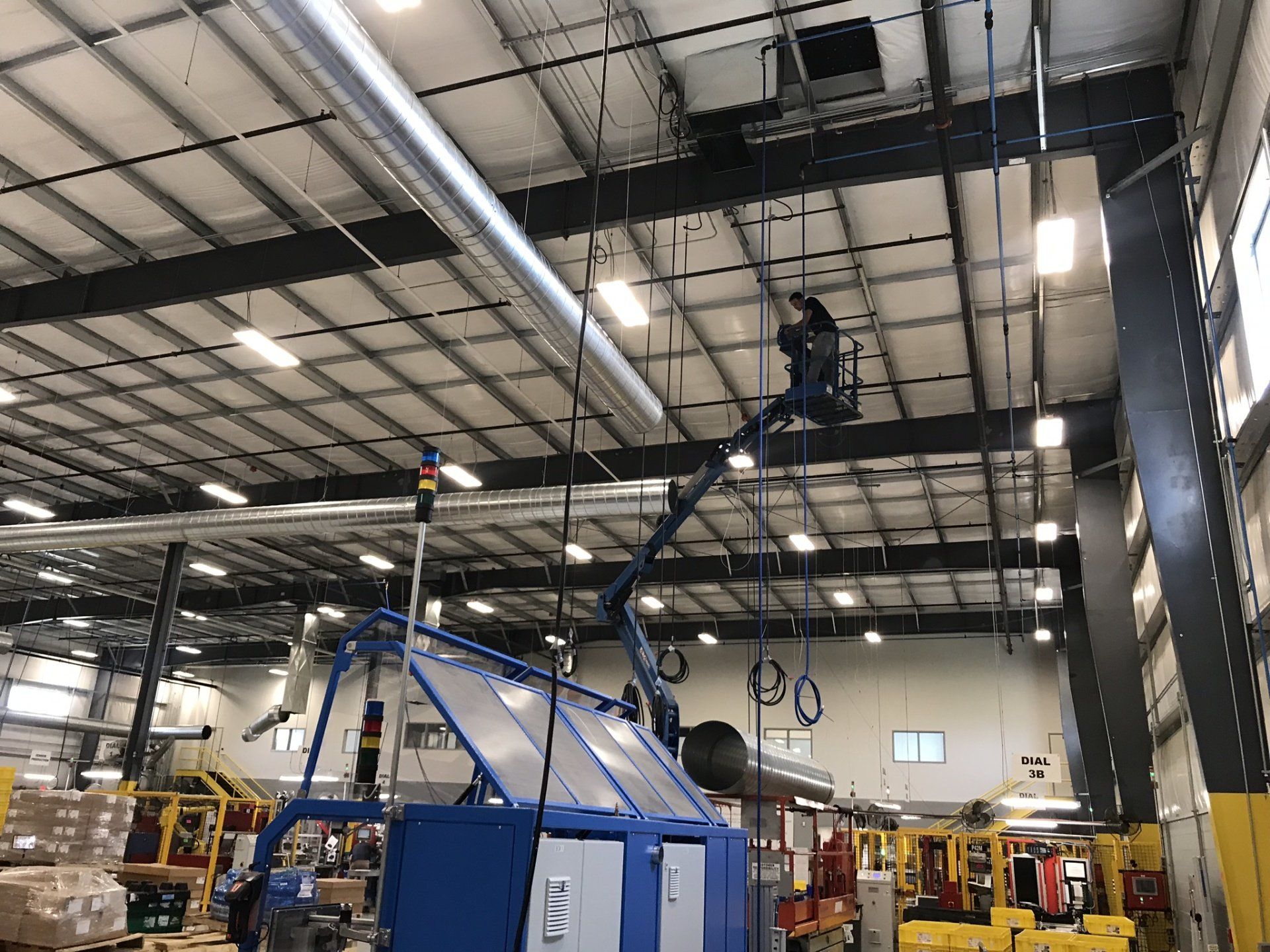 a man is working on a machine in a large warehouse .