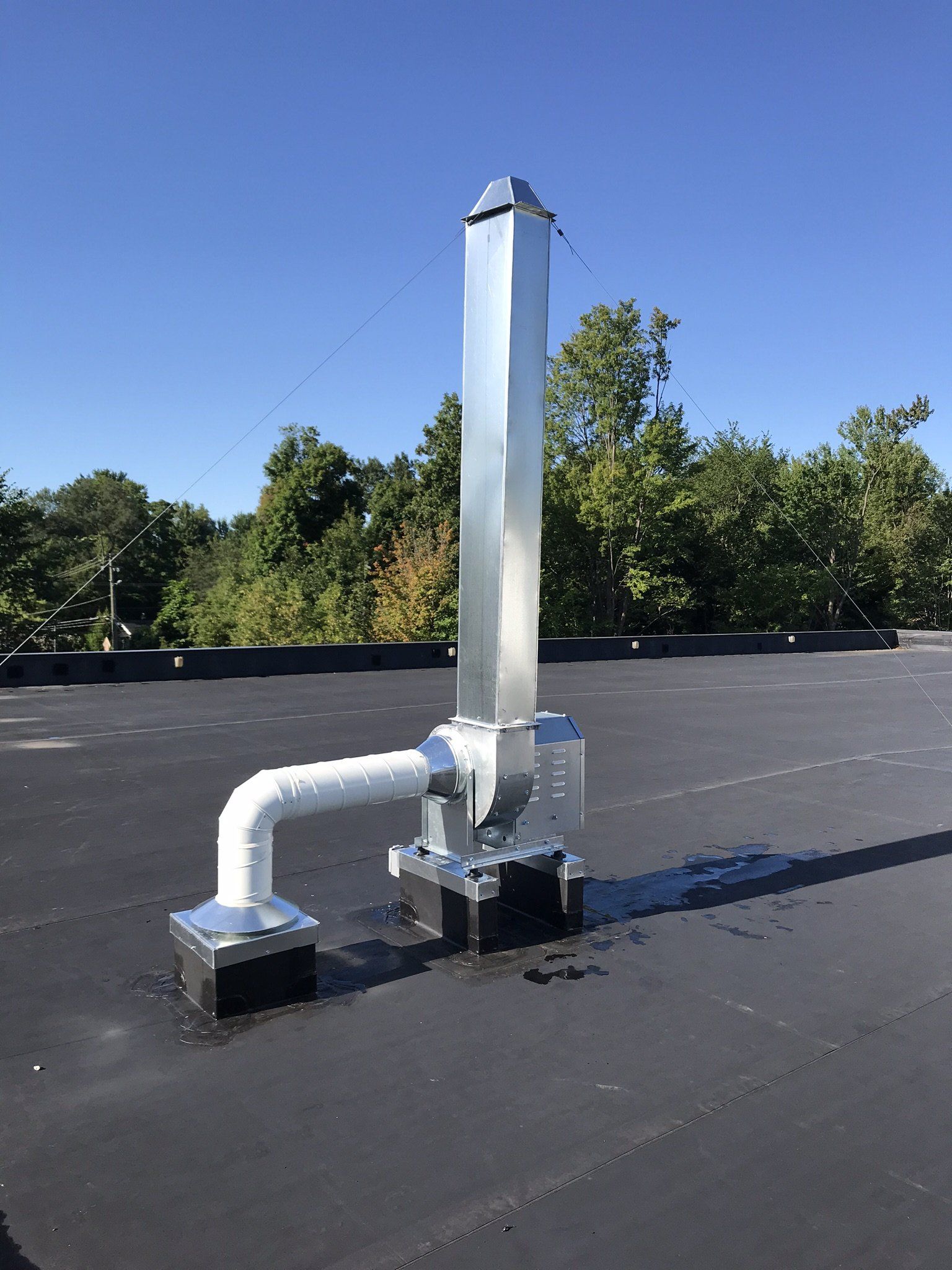 a metal pipe is sitting on top of a black roof .