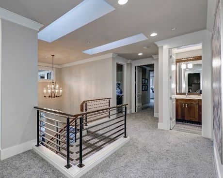 A hallway with stairs and a skylight in the ceiling