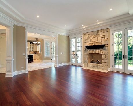 An empty living room with hardwood floors and a fireplace