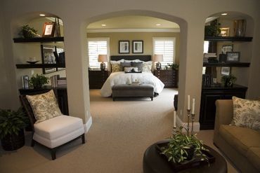 A bedroom with a couch and chairs and a bed