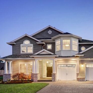 A large house with a lot of windows is lit up at night.