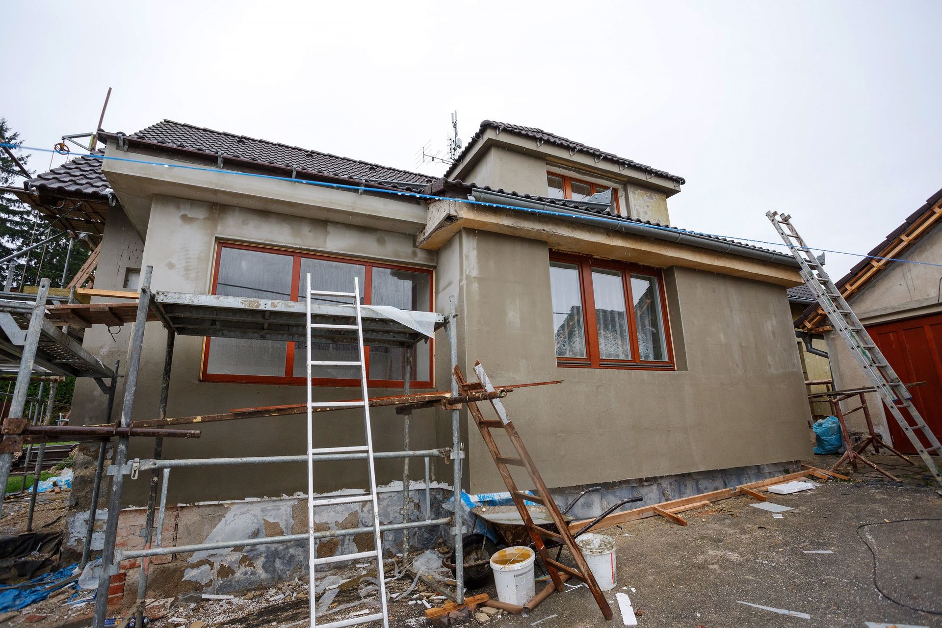 A house is being remodeled with scaffolding and a ladder.