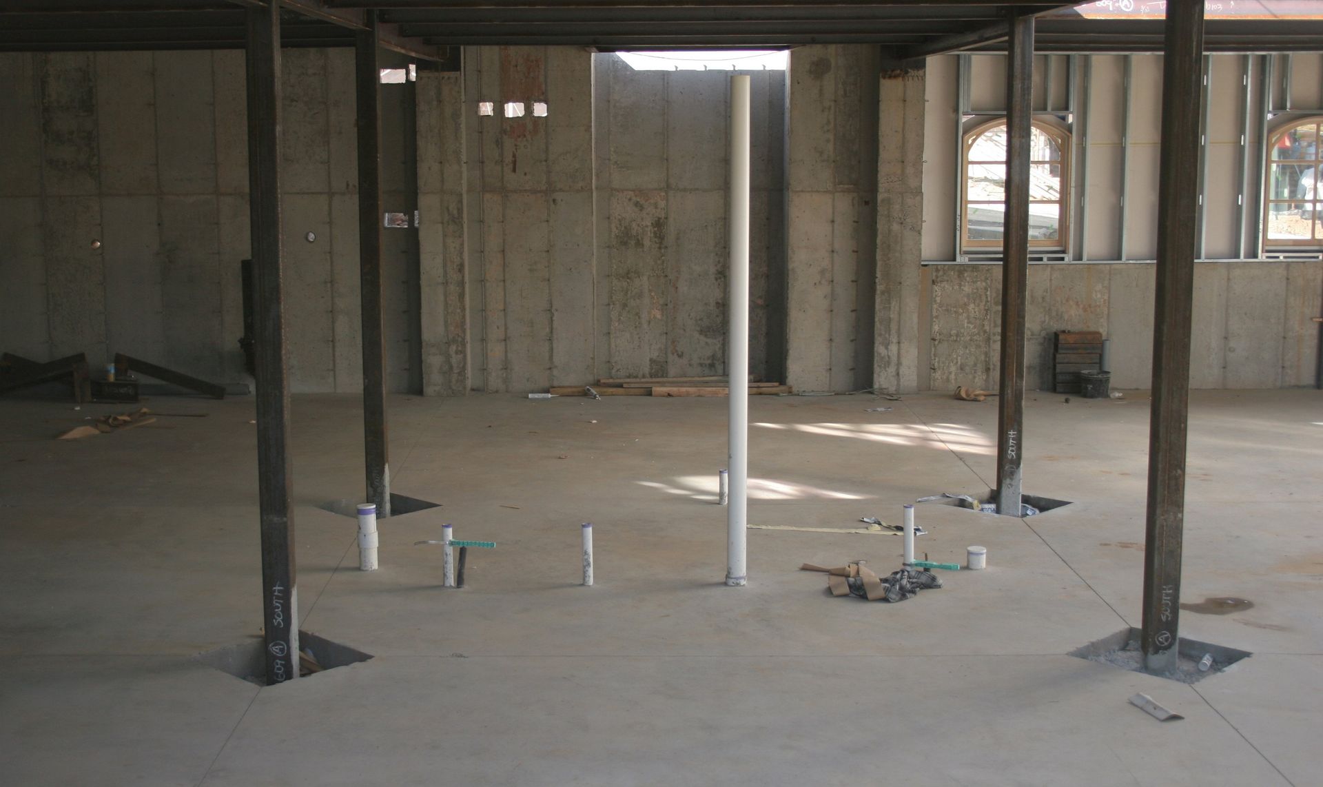 An empty room with a pipe in the middle of it.