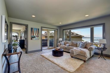 A living room with a couch , coffee table , and large windows.
