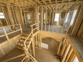 A house is being built with wooden beams and stairs.