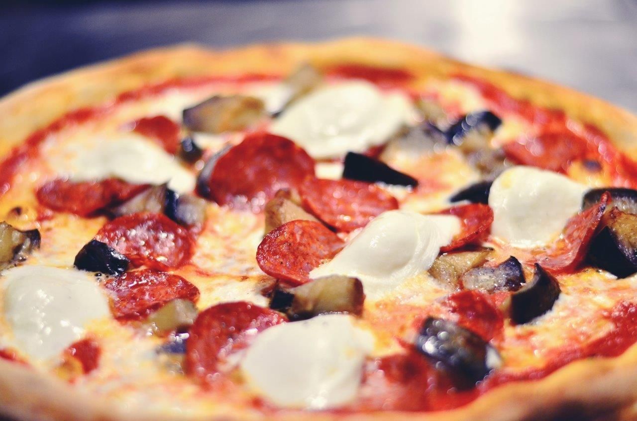 Pizza con peperoni, melanzane e mozzarella.