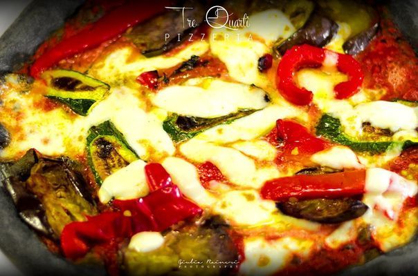 Pizza vegetariana con peperoni rossi, zucchine, melanzane e mozzarella.