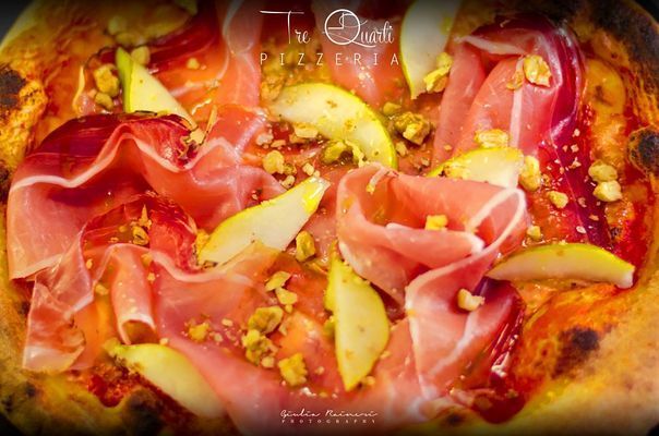 Pizza con prosciutto, fette di pera e noci.