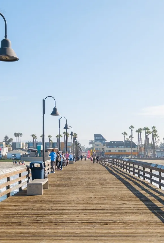 A long wooden pier with people walking along it.