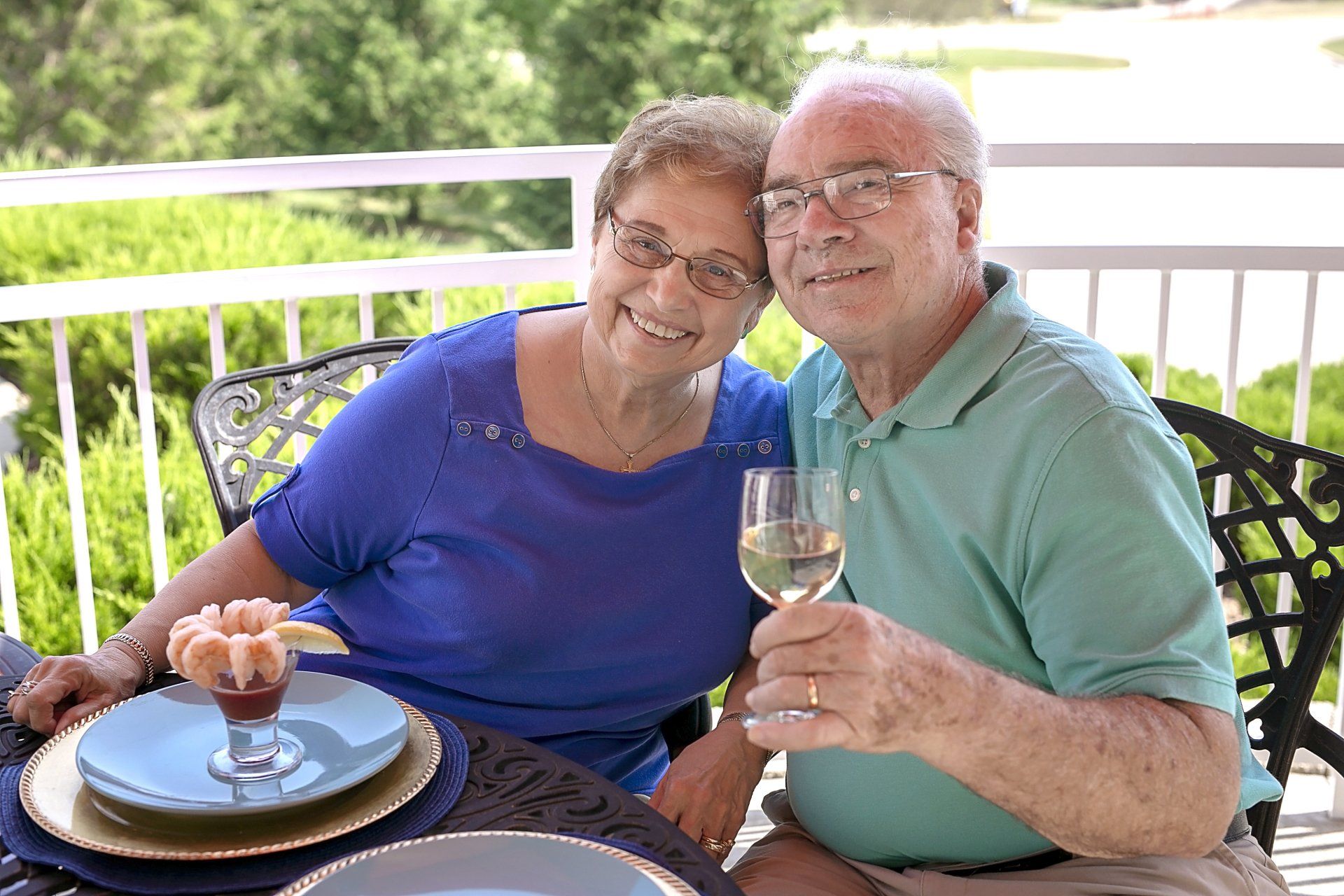 Couple drinking wine and eating appetizers outside on the patio of Landmark Commons dining room