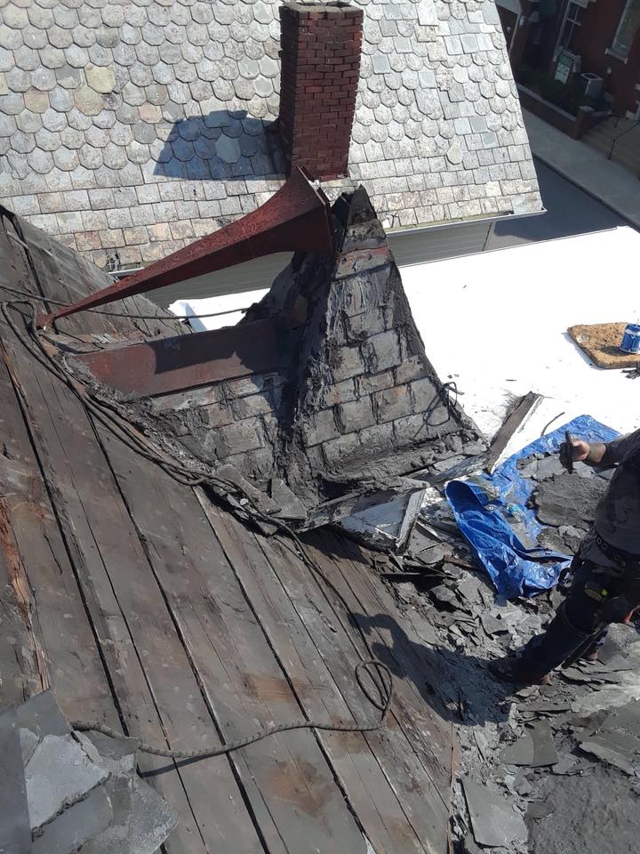 A man is working on the roof of a house.