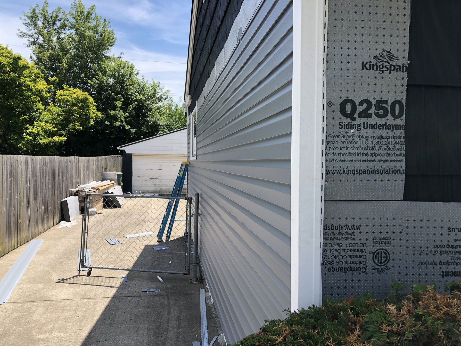 A side view of a house with siding being installed