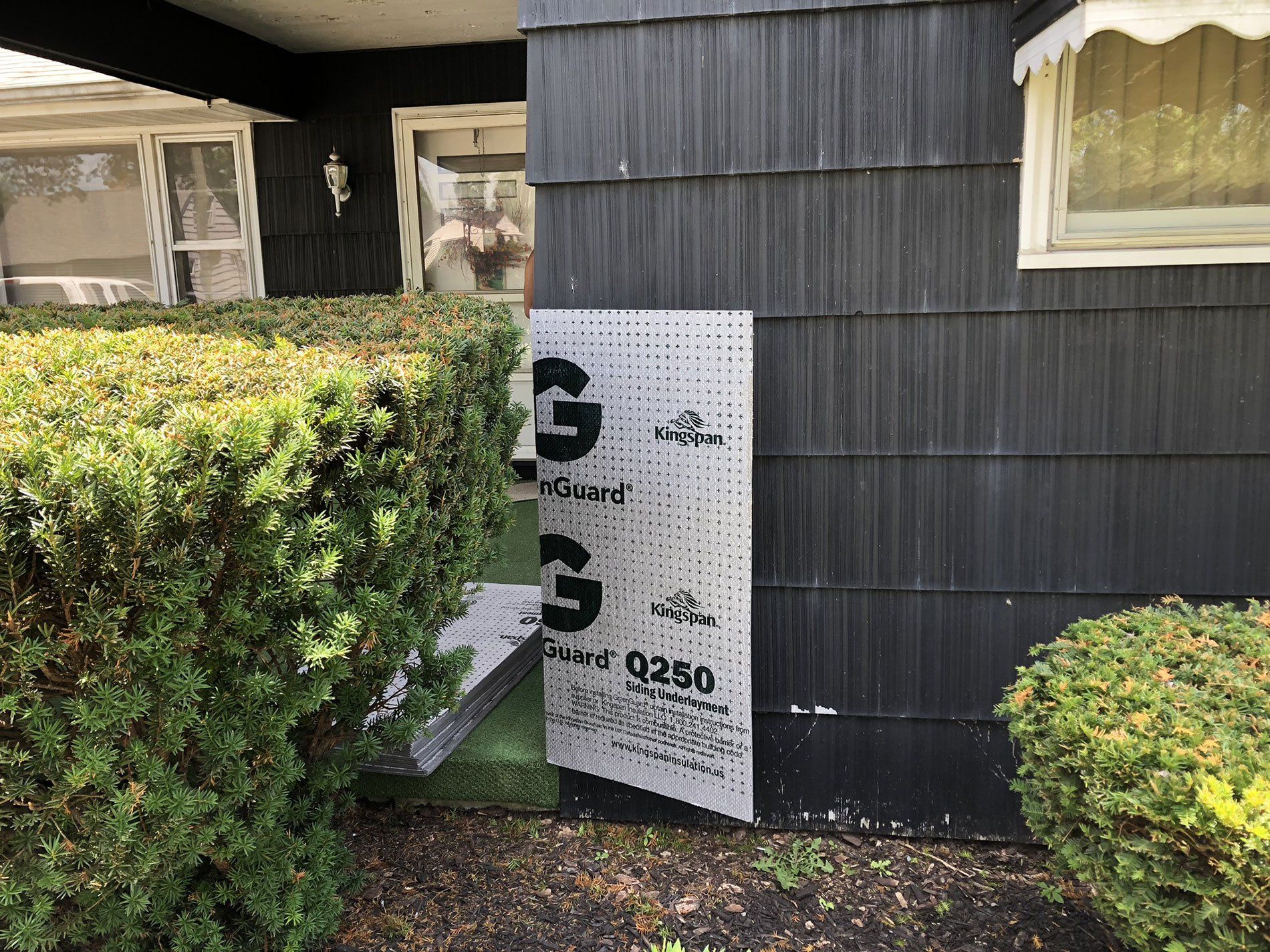 A black house with a sign on the side of it.