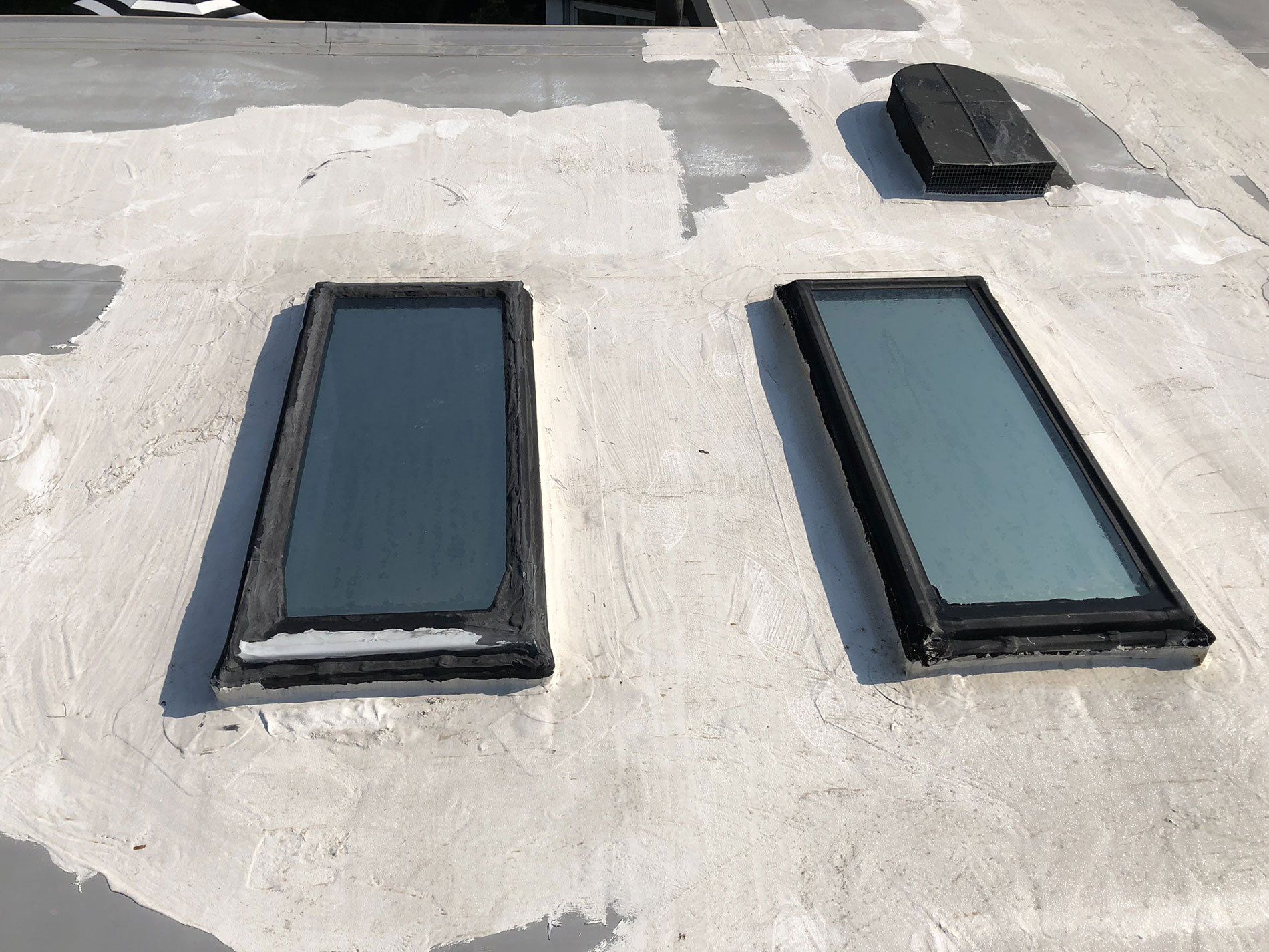 Two skylights are sitting on top of a concrete roof.