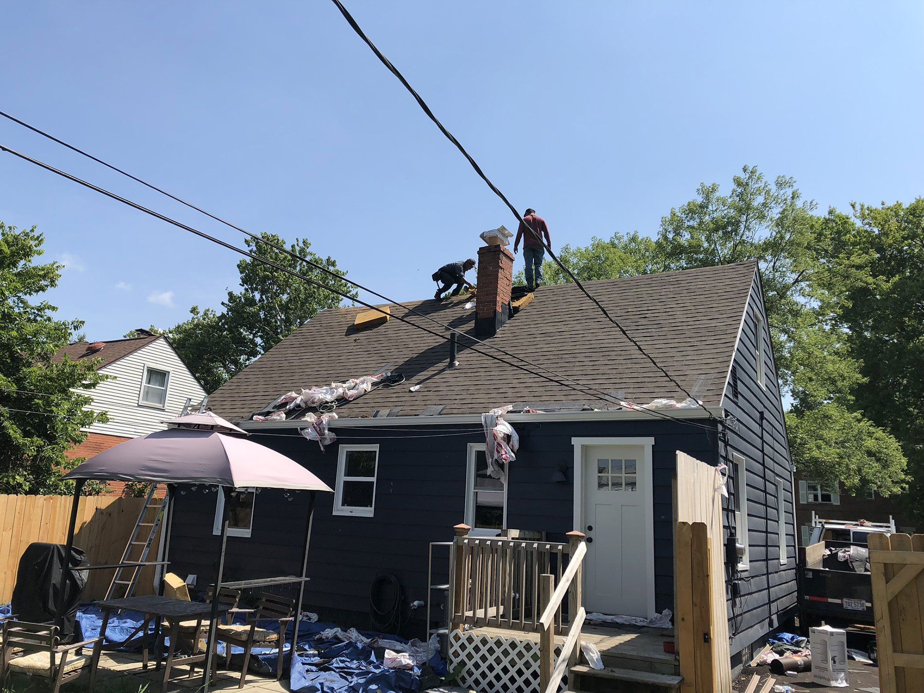 A group of people are working on the roof of a house.