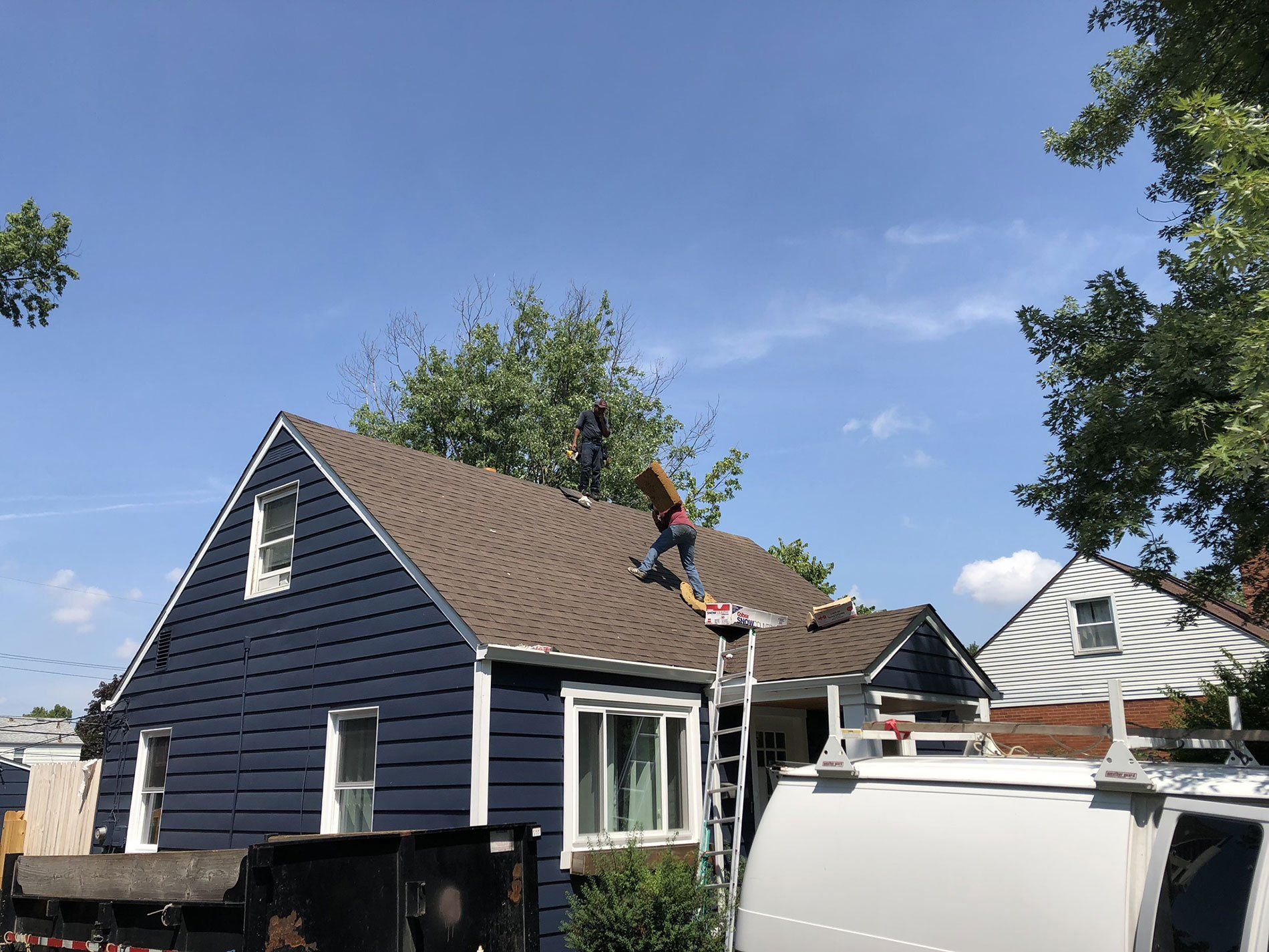 A man is working on the roof of a house.