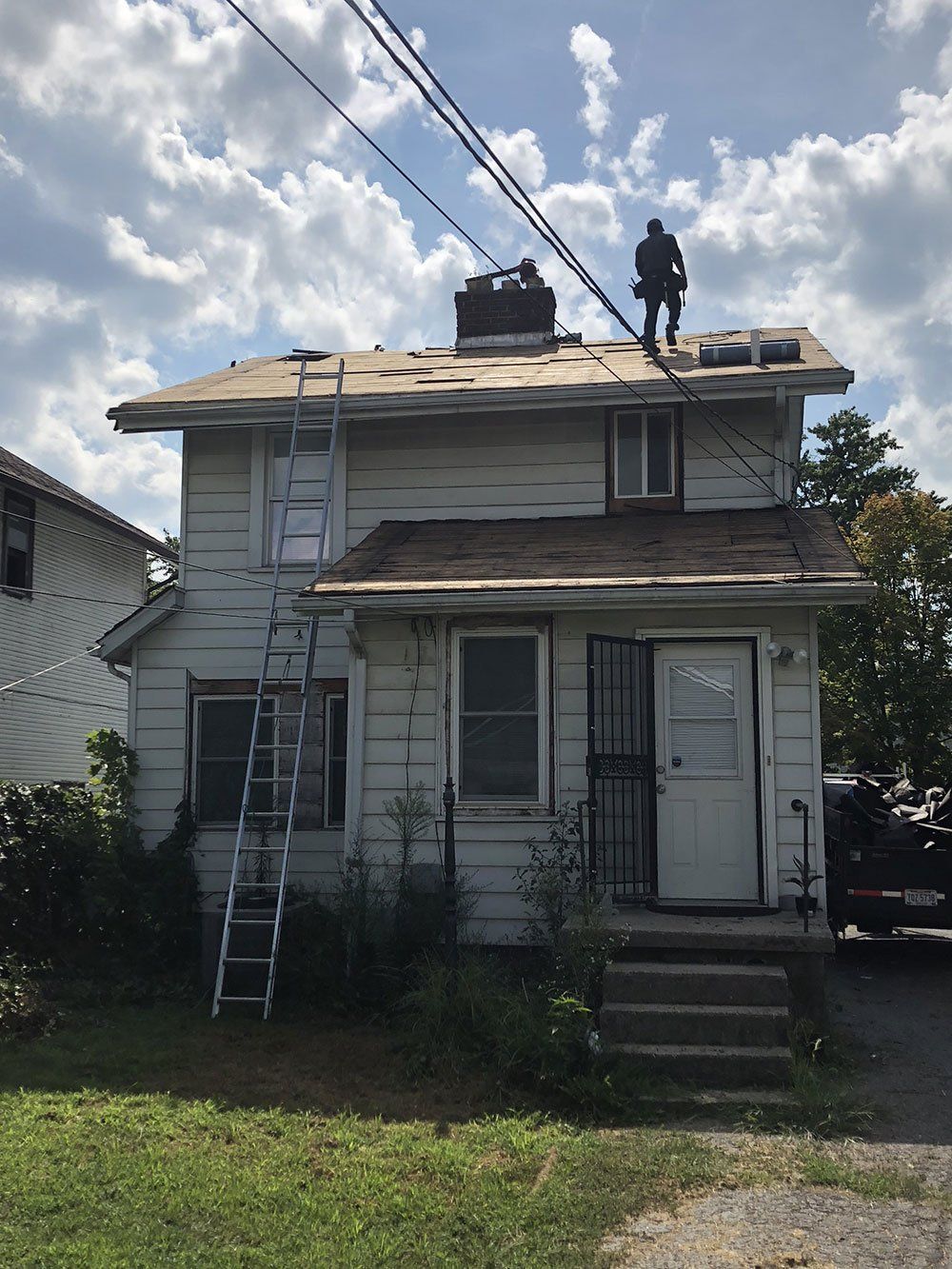 A man is working on the roof of a house.