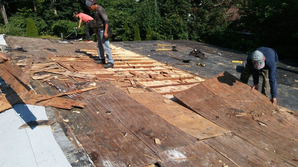 A group of men are working on a roof.