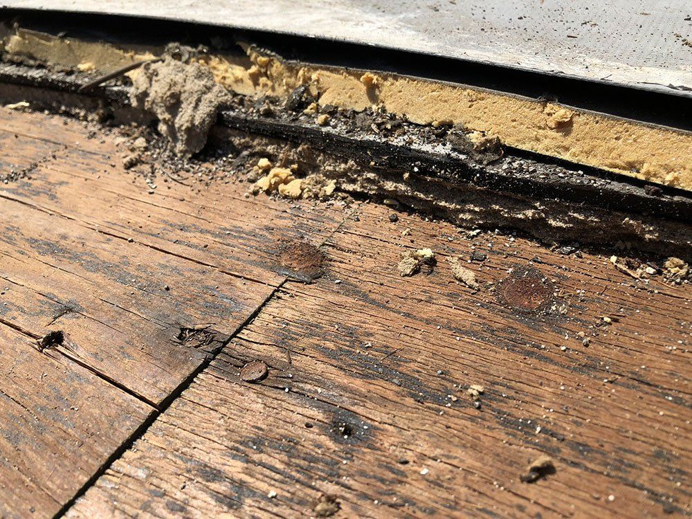 A close up of a wooden floor with a roof in the background.