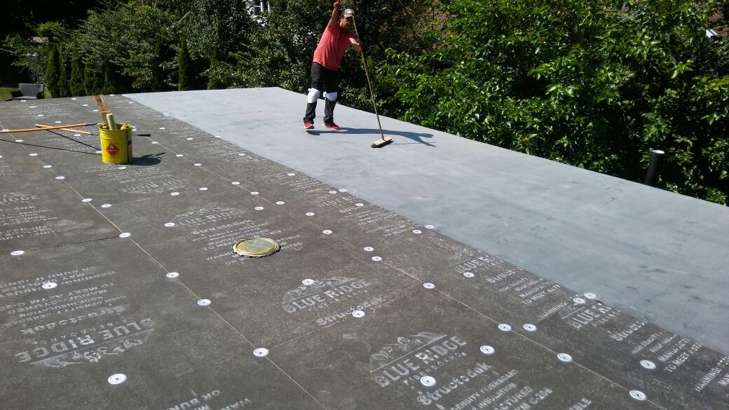 A person is standing on top of a roof.