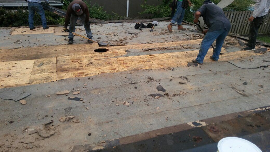 A group of men are working on a roof.