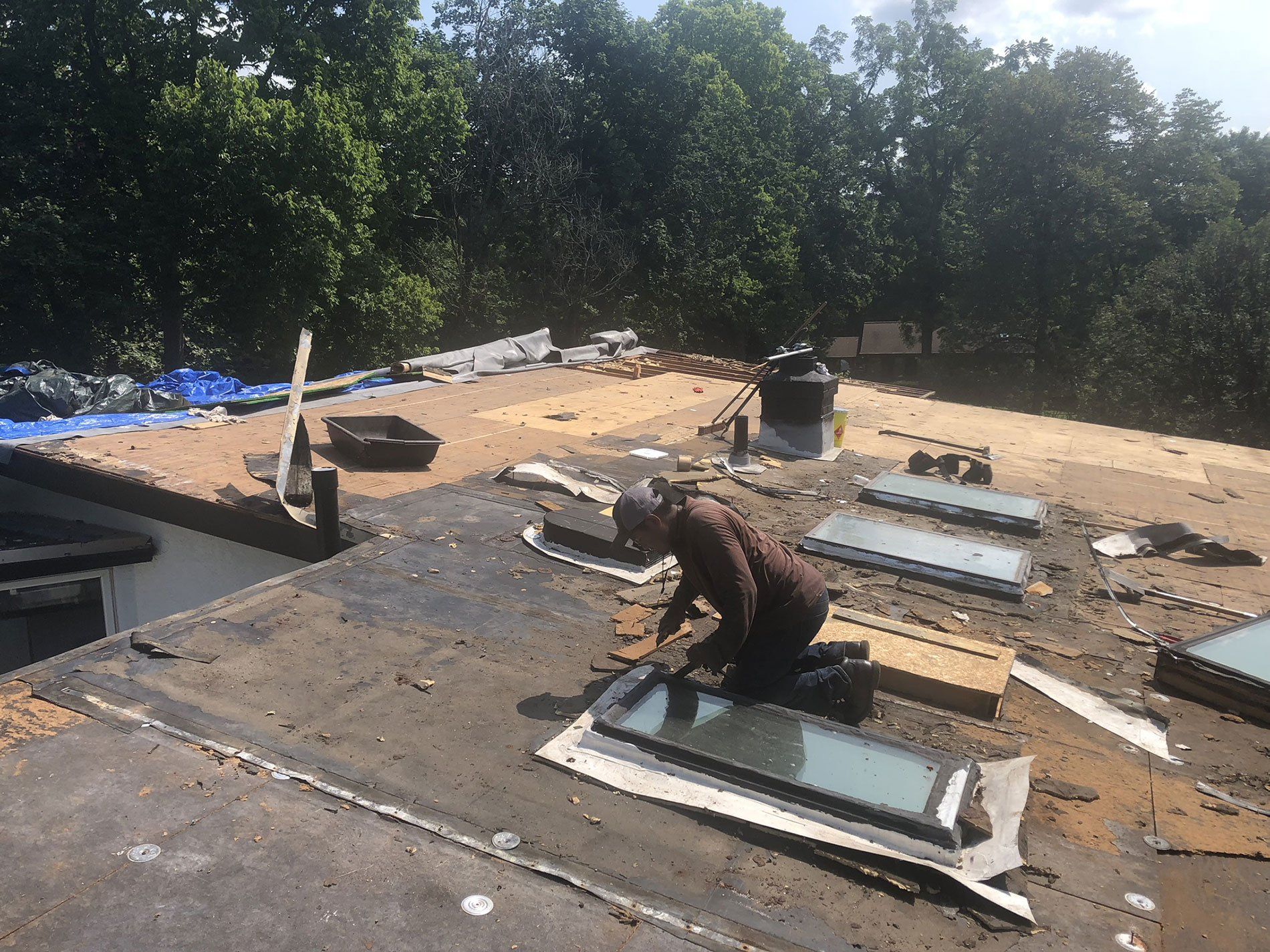 A man is working on the roof of a house.