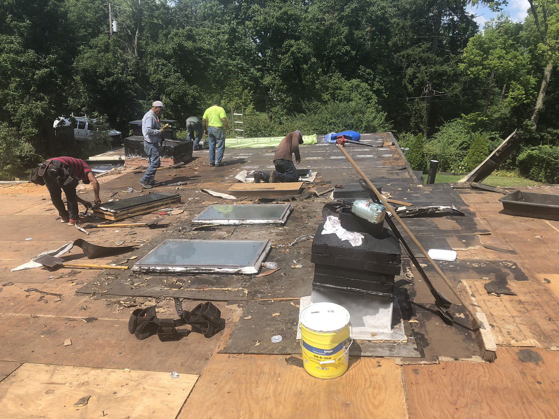 A group of men are working on a roof.