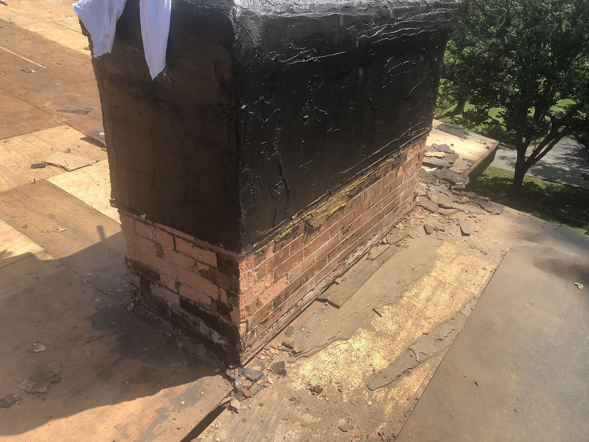 A brick chimney is sitting on top of a roof.