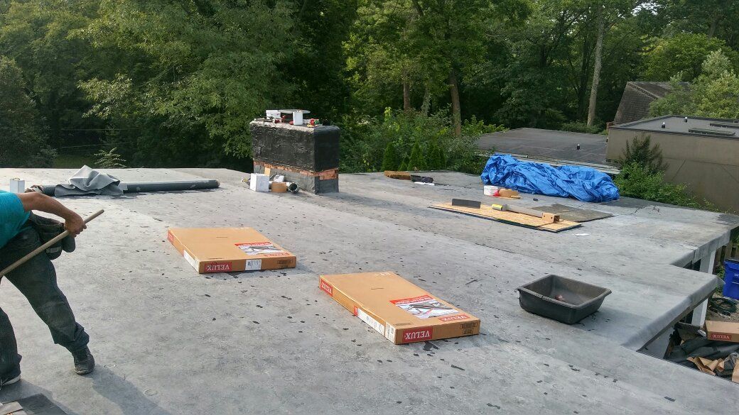 A man is working on a roof with a broom.