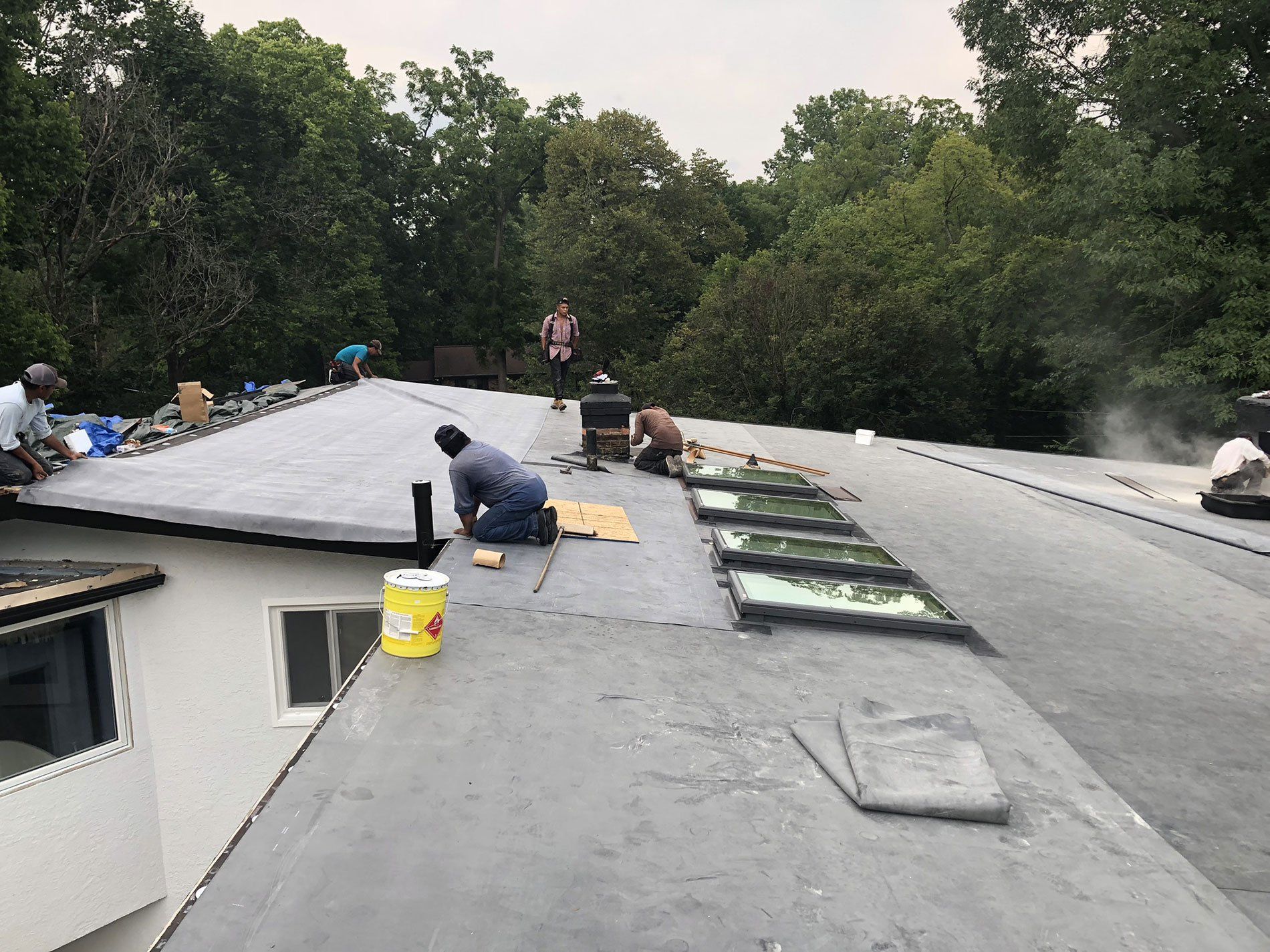 A group of people are working on the roof of a house.