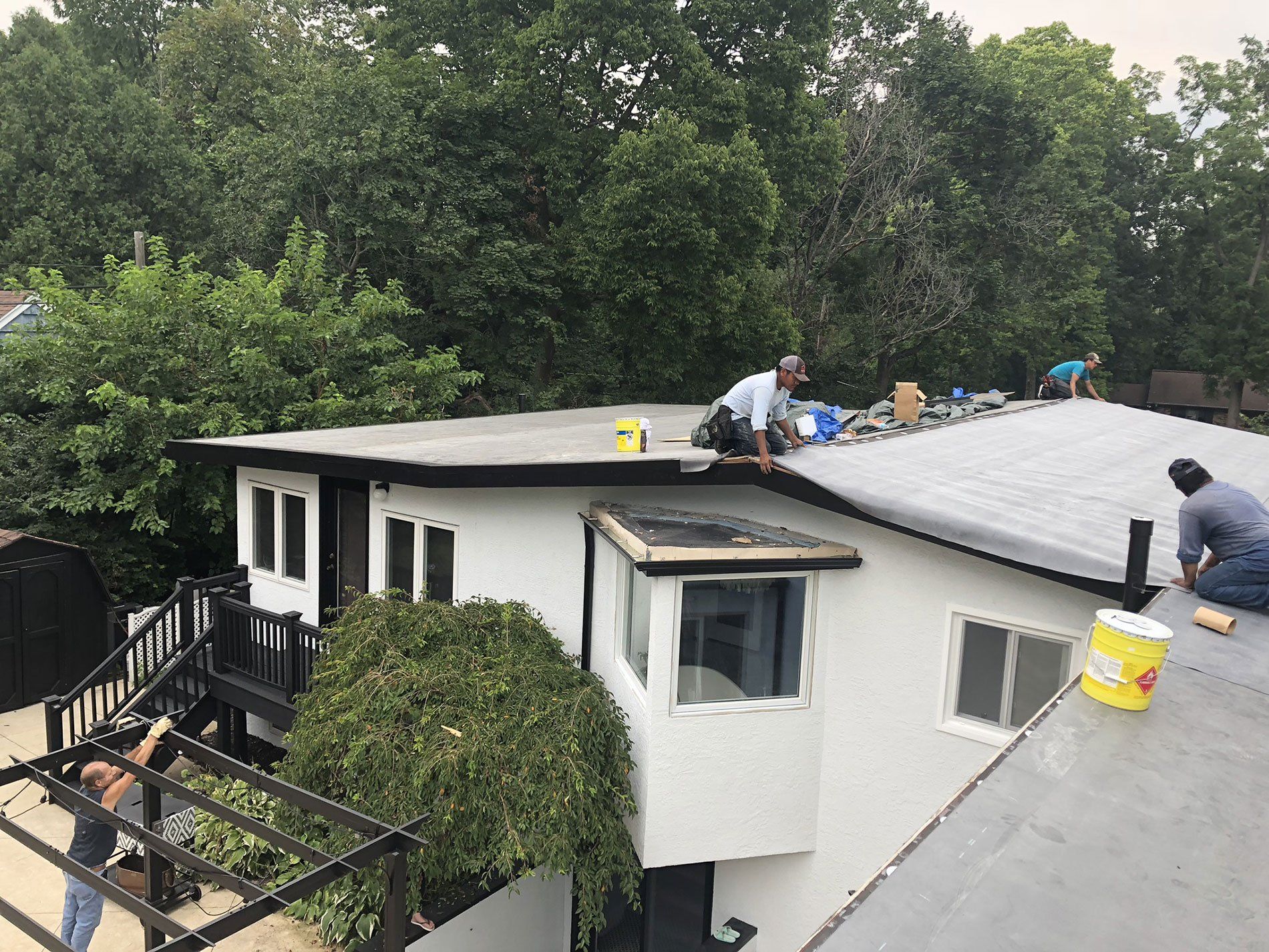 A group of men are working on the roof of a house.