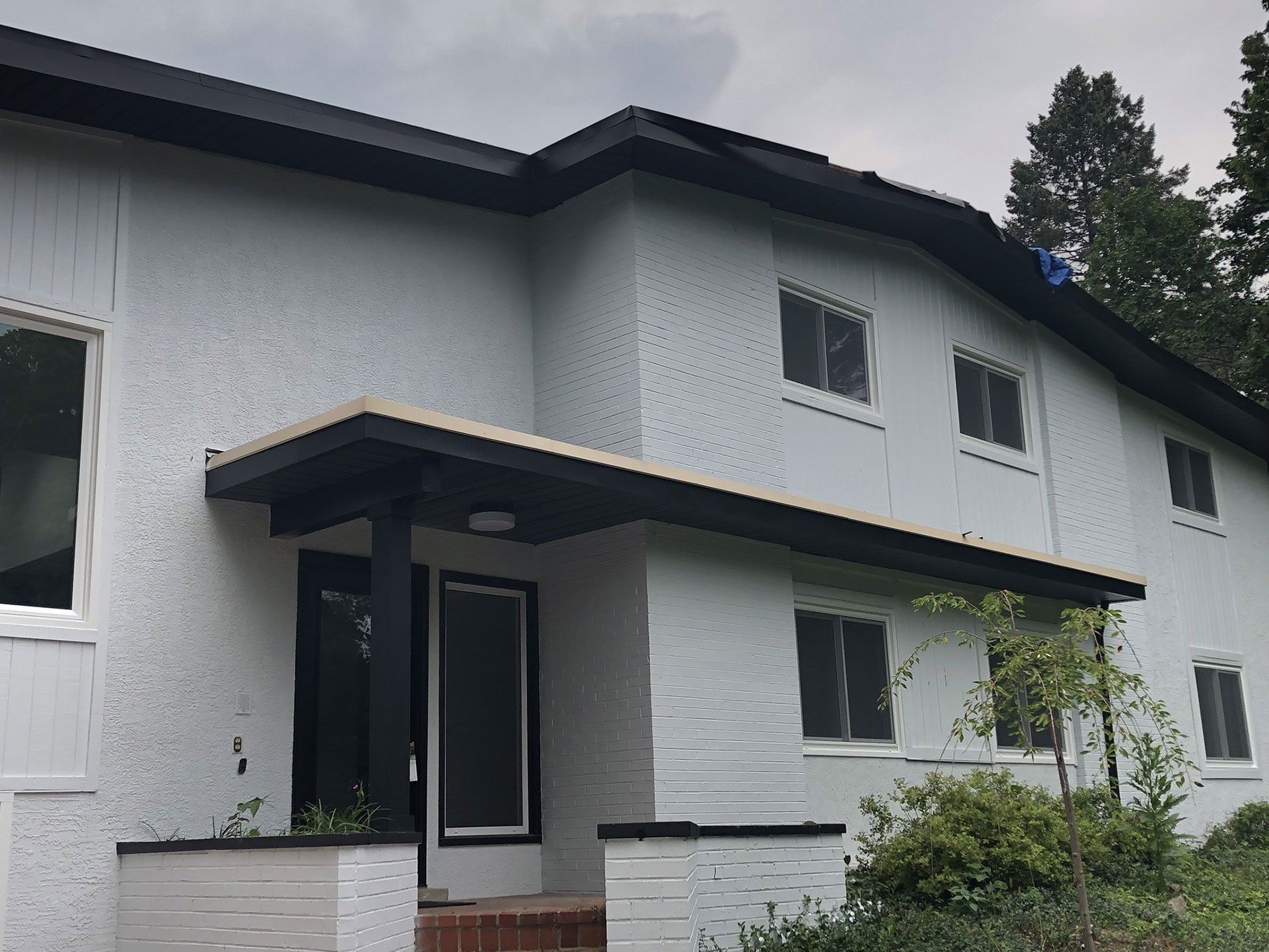 A white house with a black roof and a black door