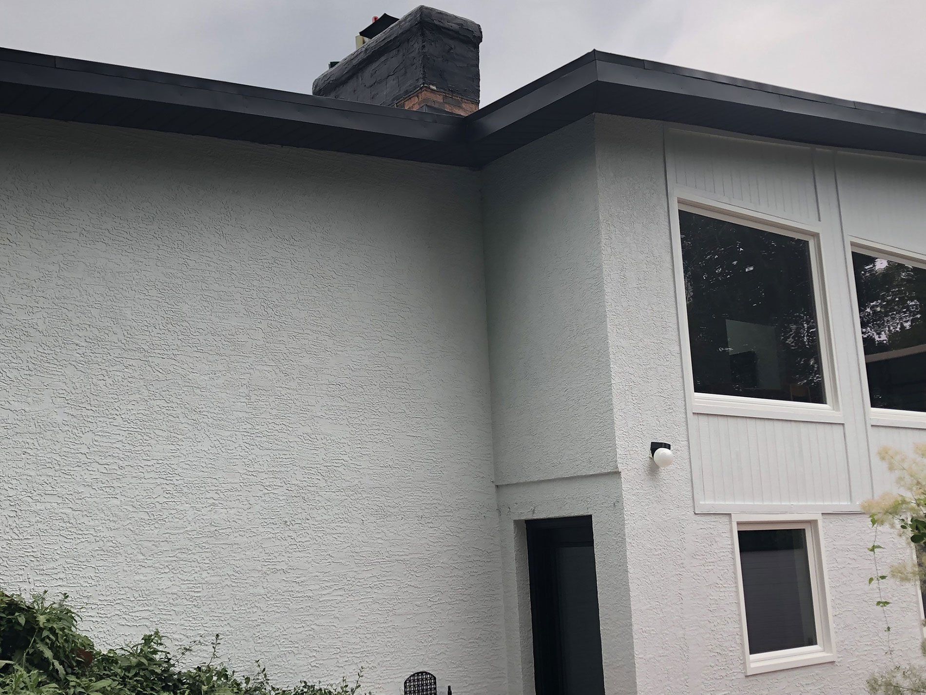 A white house with a chimney on the roof