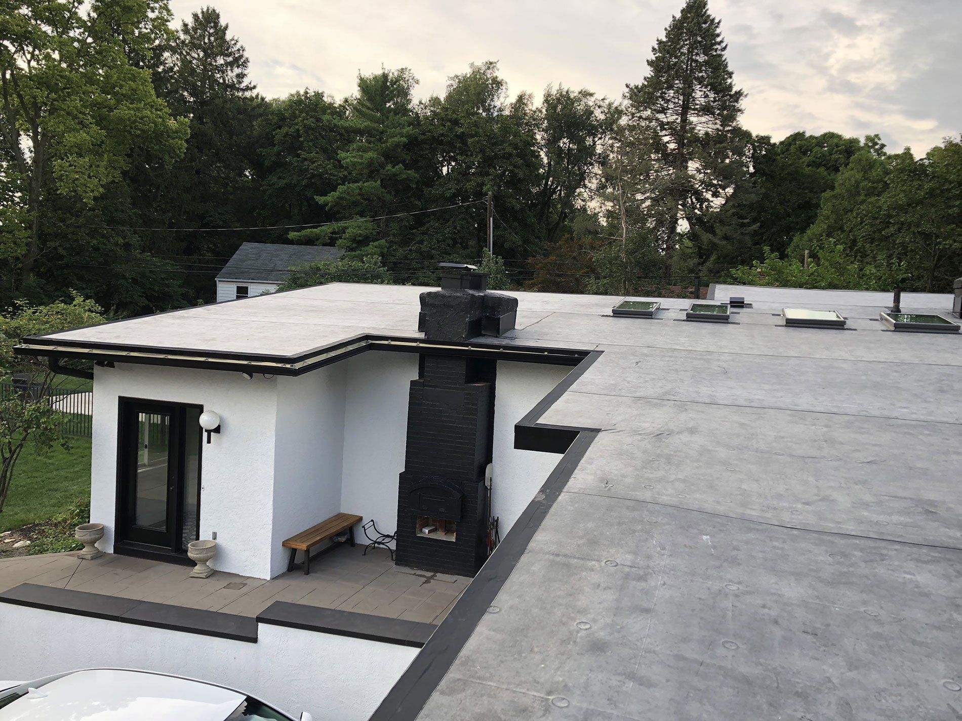 A white house with a black chimney on the roof