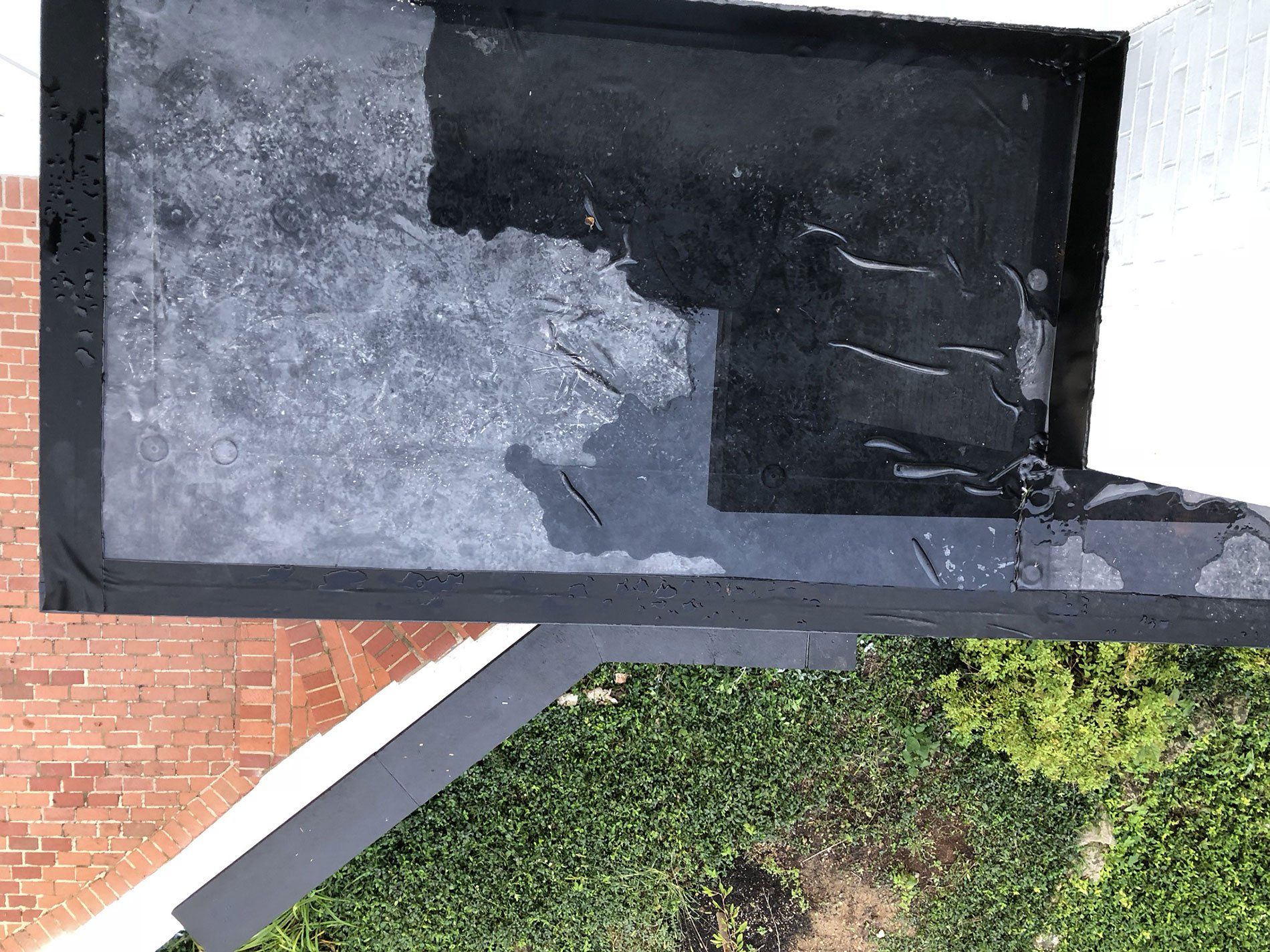 A black box is sitting on top of a brick wall.
