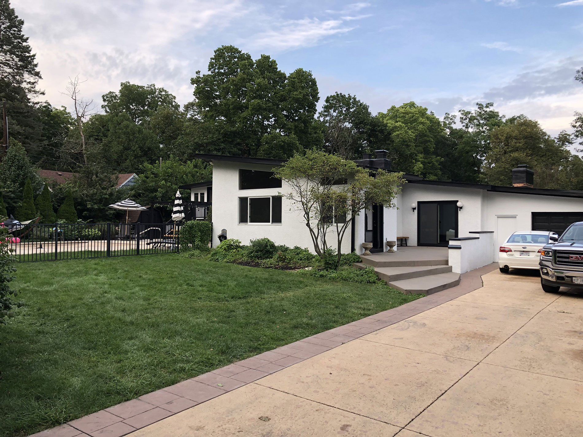 A white house with cars parked in front of it