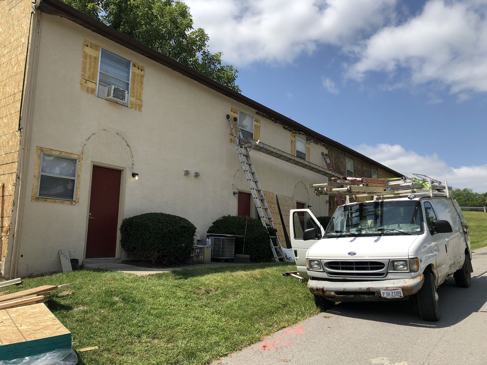 A white van is parked in front of a building.