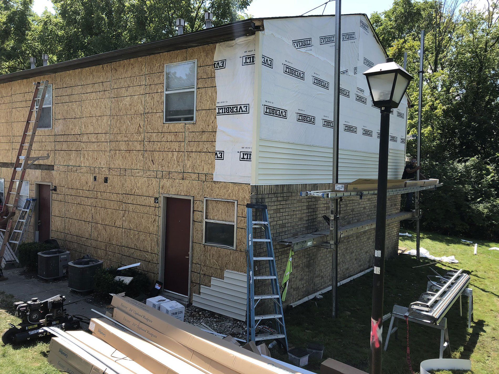 A house is being remodeled with siding being installed.