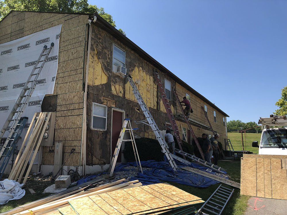 A group of people are working on the side of a building.