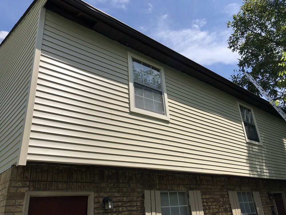 A house with a white siding and a red garage door.