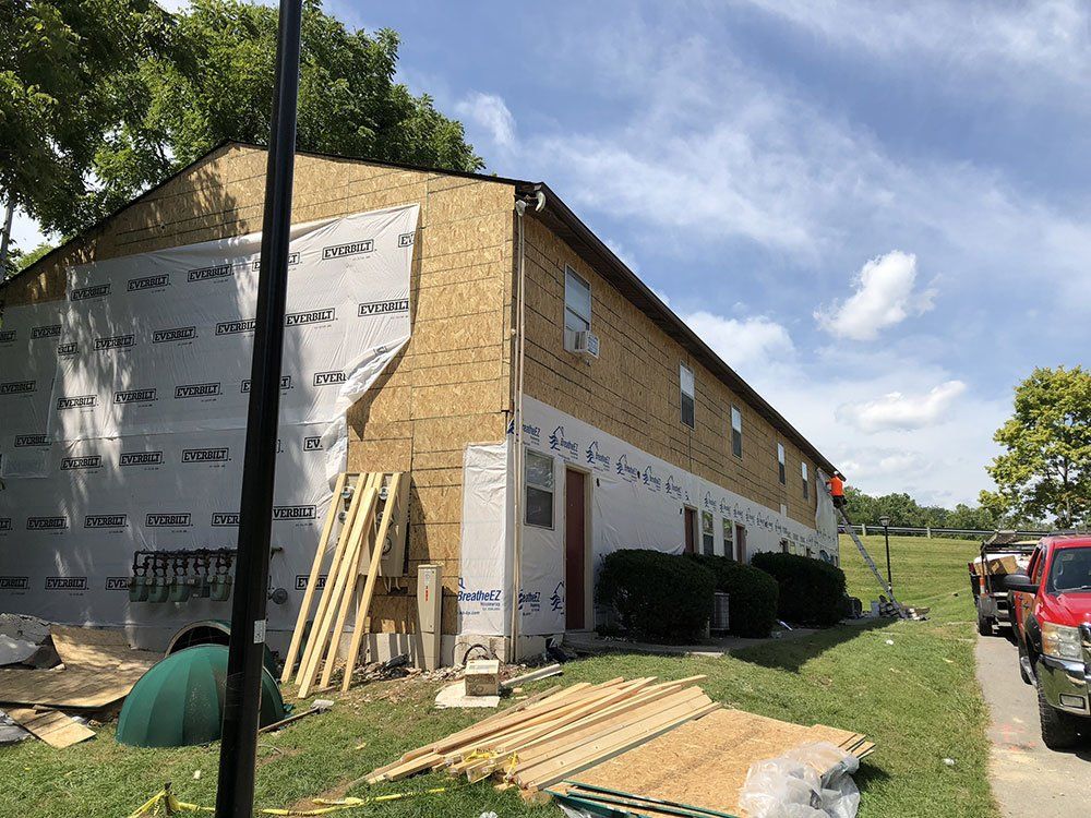 A building is being remodeled with a lot of siding being installed.