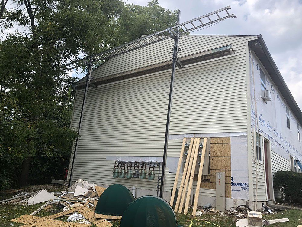 A house with a ladder on top of it is being remodeled.