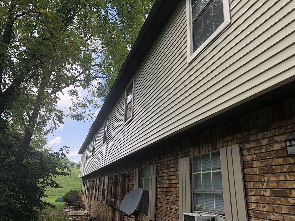 A large house with a lot of windows and a satellite dish on the side of it.