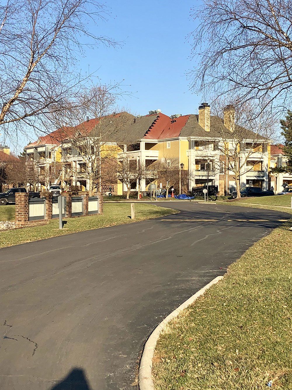 A road leading to a building with a red roof.